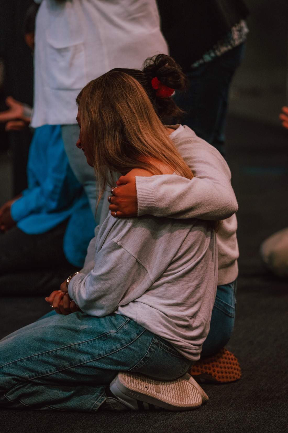 A woman comforted in prayer during a Creative Church service